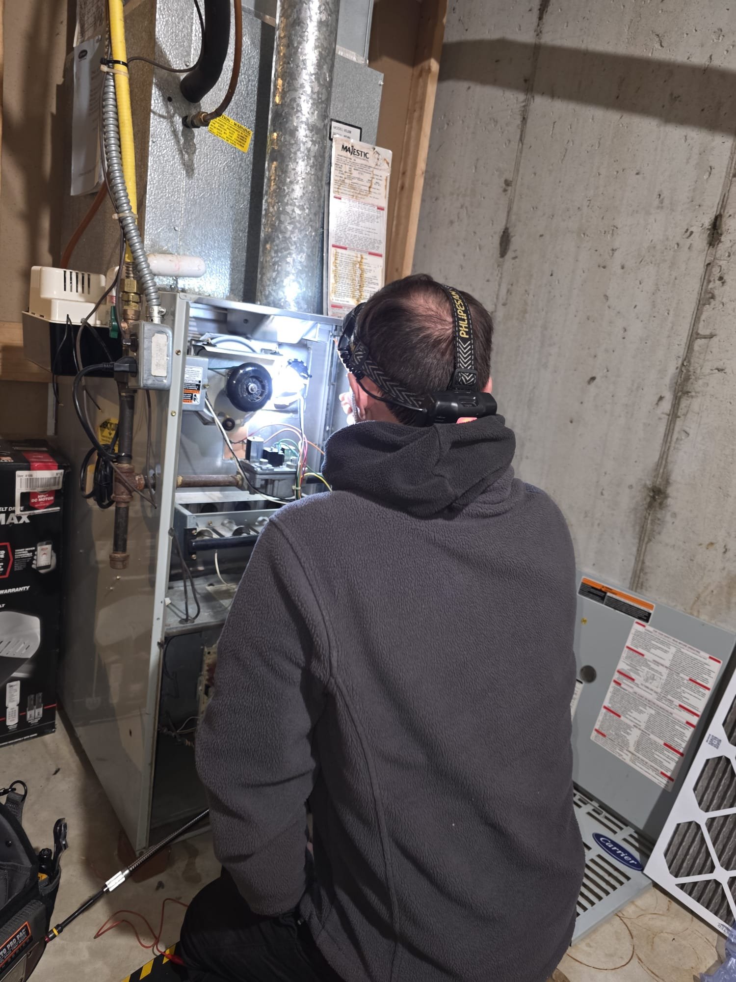 Technician with a headlamp diagnosing an open furnace