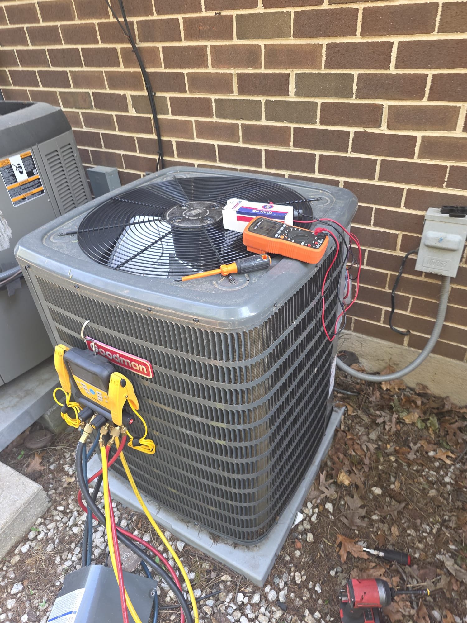 Goodman condenser with gauges and meter during a repair call