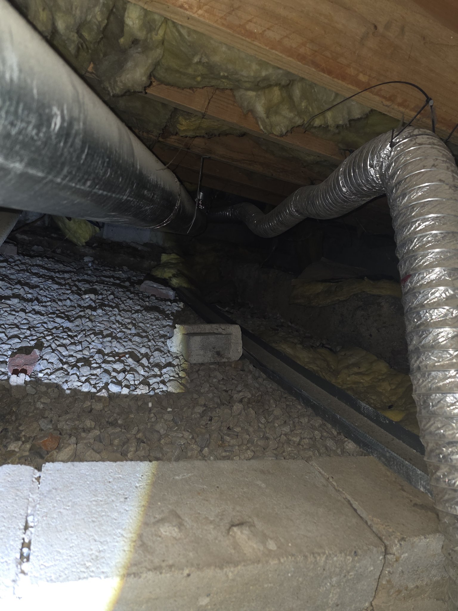 Old foil dryer hose in a crawl space before replacement