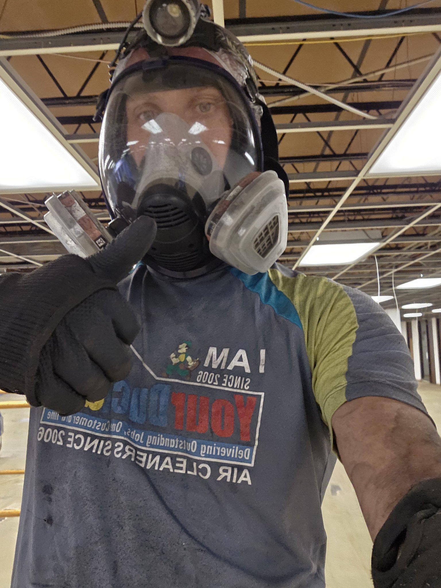 Your Duct Guy technician in full respirator gear giving a thumbs up