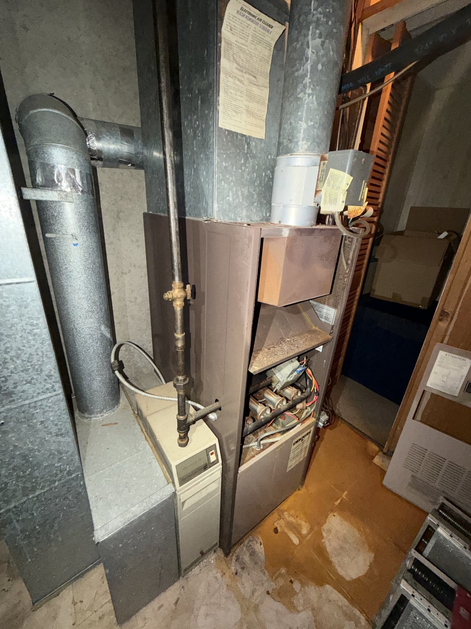 Old rusted furnace before replacement, panels off