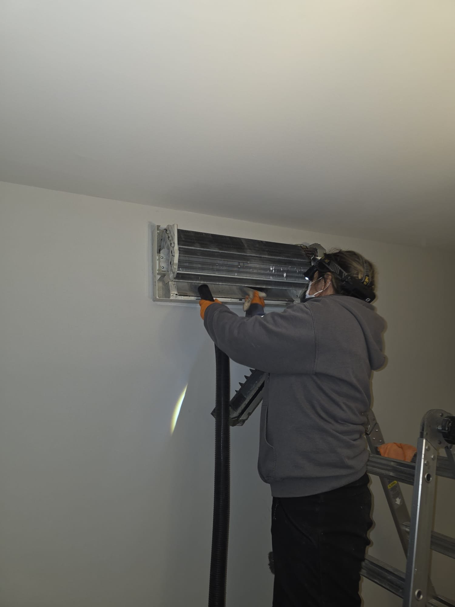 Technician Cleaning A Split System Coil